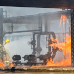 Fire fighters battling remains of a fire explosion at an oil refinery